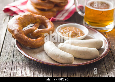 Die bayerische Weißwurst, Brezel und Senf an der Platte. Stockfoto