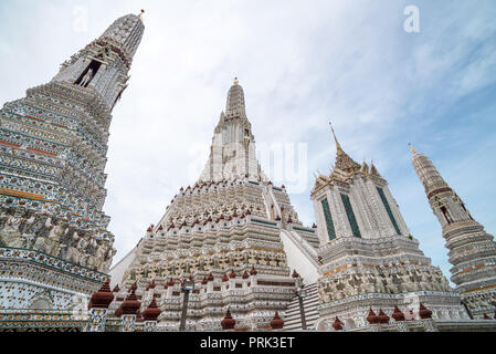 Von unten Blick auf wunderschöne ornamentale Buddhistische Wat Arun Tempel in Bangkok auf dem Hintergrund von blue Clear Sky Stockfoto