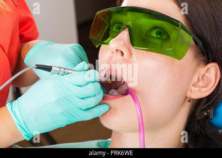 Zahnarzt über eine professionelle zahnmedizinische Laser für die orale Behandlung Stockfoto