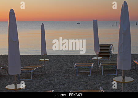 Sonnenaufgang über der Adria im Spätsommer an der italienischen Riviera in der Nähe von Porto Recanati und Numana in Ancona mit Fischerbooten in der Ferne Stockfoto