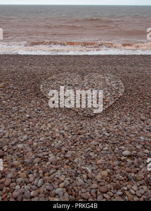 Große Liebe Herz Form mit Kieselsteinen am Strand gemacht. Vertikale crop. Stockfoto