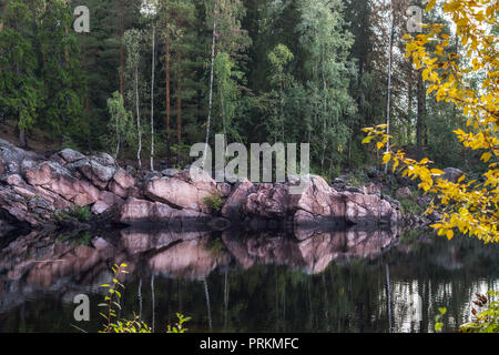 Die felsigen Ufer des Flusses von rosa Stein auf der Oberfläche des Wassers in der finnischen Stadt Imatra wider. Stockfoto