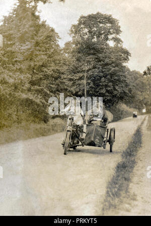 Junge Mädchen und Dame auf einem frühen Veteran Motorrad und Korbwaren seitenwagen Kombination in einem Land Lane in den frühen 1900s Stockfoto