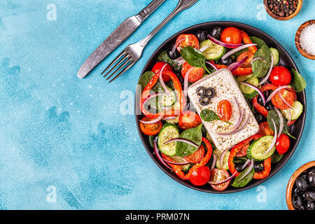 Griechischer Salat von frischen Gurke, Tomate, Paprika, Spinat, rote Zwiebel, Fetakäse und Oliven mit Olivenöl. Stockfoto