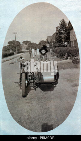 Stilvolle Dame tragen breite geströmter Hut für ein Foto sitzen in einem Veteran Motorrad Seitenwagen in den 1920er Jahren posing Stockfoto