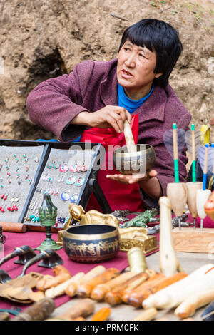 Porträt einer Frau, die Souvenirs auf dem Markt verkauft Paro auf dem Weg zum Tigernest in Bhutan Stockfoto