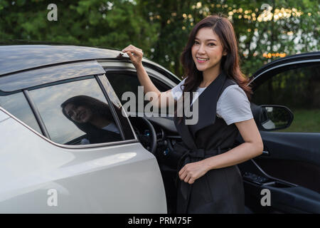 Schöne Frau stehen und die Autotür öffnen Stockfoto