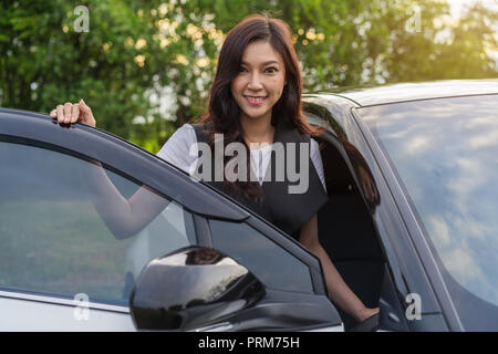 Schöne Frau stehen und die Autotür öffnen Stockfoto