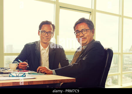 Zwei asiatische Geschäftsmann toothy Lächeln in Arbeit Büro Stockfoto