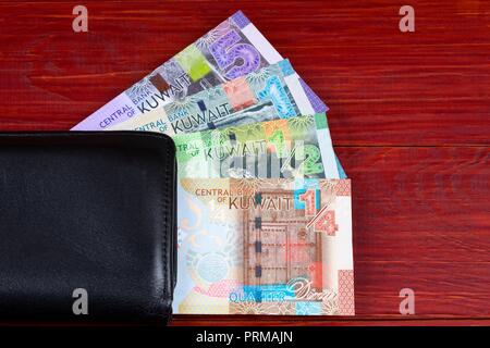 Geld aus Kuwait in der schwarzen Mappe Stockfoto