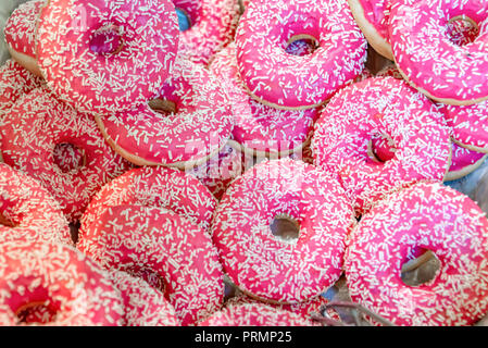Hintergrund der rosa Donuts mit Streuseln Stockfoto