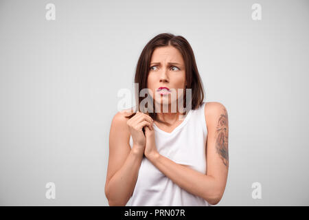 Mädchen ist besorgniserregend. Portrait von Betroffenen attraktive kaukasische Studentin holding Palmen auf der Brust und keuchend von Furcht und Angst, die dazu beitragen wollen, Stockfoto