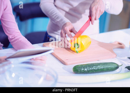 Nahaufnahme von Frau mit scharfen Messer und schneiden Pfeffer Stockfoto