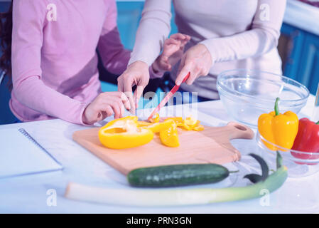 Nahaufnahme von zwei Menschen Schneiden von Gemüse in der Küche Stockfoto