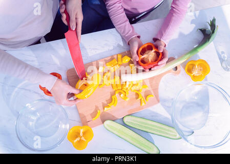 Blick von oben auf die zwei Personen Schneiden frisches Gemüse für Salat Stockfoto