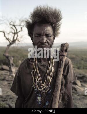 Oktober 3, 2018 - Lake Eyasi, Ngorongoro, Tansania - Alagu (68), führt seine Axt für Honig in den Bäumen zu suchen. Die hadza sind eine der letzten verbleibenden Gesellschaften, die in der Welt bleiben, dass rein vom Jagen und Sammeln überleben. Sehr wenig wurde in der Art und Weise, wie der Hadza ihr Leben verändert. Aber es wurde immer schwieriger für sie zu verfolgen die Hadza Lebensart geworden. Entweder die Hadza wird einen Weg finden, ihr Land zu sichern - Rechte den Zugang zu sauberem Wasser quellen und wilden Tieren, oder die Hadzabe lifestyle Verschwinden zu haben, mit der Mehrheit von Ihnen zu Stockfoto