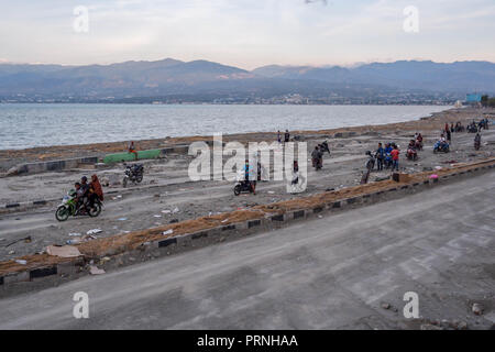 Palu, Indonesien. 4. Okt 2018. Bewohner gesehen der Überquerung der beschädigten Cumi Cumi-Straße nach dem Erdbeben und Tsunami. Eine tödliche Erdbeben der Stärke 7.7 Ausmaß und der Tsunami Welle verursacht durch die Stadt von Palu und viel von der Gegend in Zentral-sulawesi zerstört hat. Nach Ansicht der Beamten, die Zahl der Todesopfer von verheerenden Erdbeben und Tsunami steigt auf 1.347, rund 800 Menschen in Krankenhäuser sind schwer verletzt und rund 62.000 Menschen in 24 Flüchtlingslagern rund um die Region vertrieben worden. Credit: SOPA Images Limited/Alamy leben Nachrichten Stockfoto