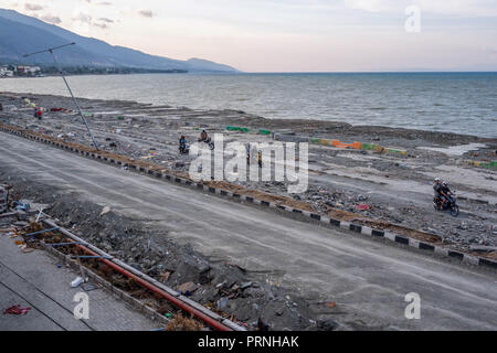 Palu, Indonesien. 4. Okt 2018. Bewohner gesehen der Überquerung der beschädigten Cumi Cumi-Straße nach dem Erdbeben und Tsunami. Eine tödliche Erdbeben der Stärke 7.7 Ausmaß und der Tsunami Welle verursacht durch die Stadt von Palu und viel von der Gegend in Zentral-sulawesi zerstört hat. Nach Ansicht der Beamten, die Zahl der Todesopfer von verheerenden Erdbeben und Tsunami steigt auf 1.347, rund 800 Menschen in Krankenhäuser sind schwer verletzt und rund 62.000 Menschen in 24 Flüchtlingslagern rund um die Region vertrieben worden. Credit: SOPA Images Limited/Alamy leben Nachrichten Stockfoto