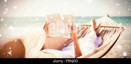 Das zusammengesetzte Bild der Frau lesen Buch über die Hängematte am Strand Stockfoto