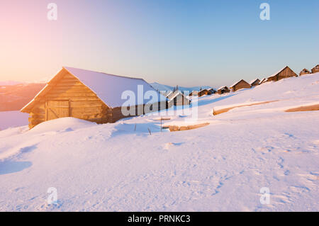 Winterlandschaft in einem Bergdorf. Holz- Häuser und Hütten im Schnee. Sonnigen morgen Stockfoto
