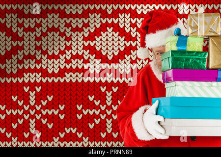 Zusammengesetztes Bild vom Weihnachtsmann versteckt sich hinter Stapeln Weihnachtsgeschenke Stockfoto