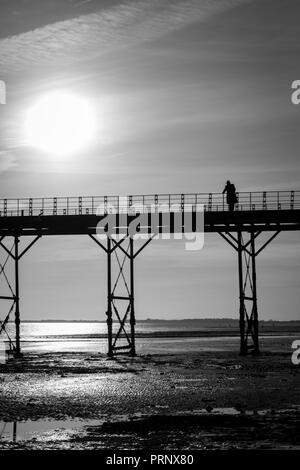 Monochrome einzelner Mann denken auf einem alten englischen Victorian seaside Pier Stockfoto