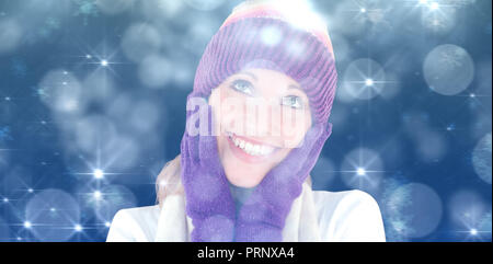Zusammengesetztes Bild der fröhliche junge Frau mit Mütze und Handschuhe im winter Stockfoto