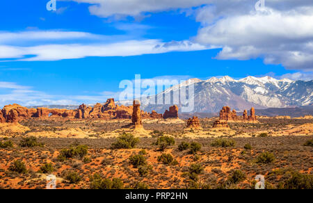 Wüstenlandschaft mit La Sal Mountains und Fenster Arch im Arches National Park, Moab, Utah, USA Stockfoto