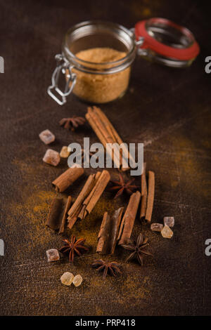 Zimtstangen, Sternanis Sprossen und karamellisierten Zucker auf einem dunklen Hintergrund. Blick von oben. Close-up. Stockfoto