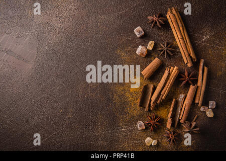 Zimtstangen, Sternanis Sprossen und karamellisierten Zucker auf einem dunklen Hintergrund. Blick von oben. Close-up. Stockfoto