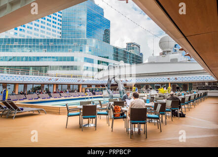 Lido Deck Swimmingpool unter Öffnen des Klappdachs Magradome Dach. Die Volendam, Holland America R Klasse Kreuzfahrtschiff. Am Hafen von Vancouver, British Columbia, Kanada angedockt. Downtown Vancouver Gebäude im Hintergrund. Stockfoto