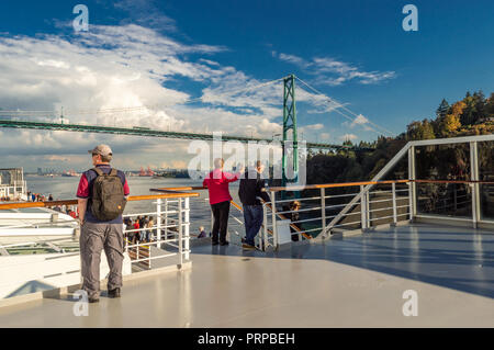 Kreuzfahrtschiff Passagiere auf der Oberseite des Holland America Die Volendam, wie es unter der Lions Gate Bridge in Burrard Inlet, Vancouver, British Columbia, Kanada auf dem Weg nach Alaska, USA. Stockfoto