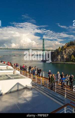 Kreuzfahrtschiff Passagiere auf der Oberseite des Holland America Die Volendam, wie es unter der Lions Gate Bridge in Burrard Inlet, Vancouver, British Columbia, Kanada auf dem Weg nach Alaska, USA. Stockfoto