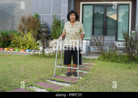 Ältere Frau zu Fuß mit Walker zu Hause Stockfoto