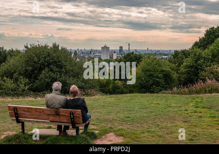 Leute haben Spaß und die Skyline von London von der Oberseite des Parliament Hill genießen, in Hampstead Heath, im Nordwesten von London. Stockfoto