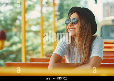 Close-up cool Hipster student Frau tragen Brillen Gläser. Kaukasische Frau mit Hut unterwegs auf einer Stadtrundfahrt Verkehrsmittel gerade die Aussicht, lo Stockfoto