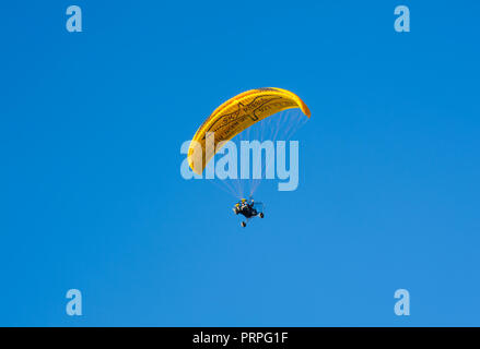 Maspalomas, Gran Canaria, Spanien - 5. Januar, 2018. Paramotorist fliegen mit gelben Fallschirm im blauen Himmel im Hintergrund Stockfoto