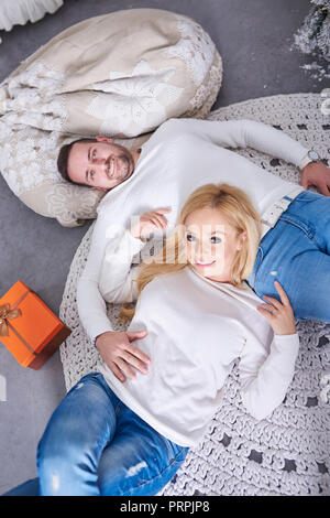 Ein schönes glückliches junges Paar auf dem Boden mit der Weihnachtsbaum und die Geschenke. Stockfoto