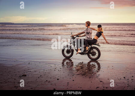 Junges Paar reiten Motorrad am Ocean Beach Stockfoto