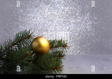 Dekorativer Hintergrund mit Tannenzweigen und goldenen Kugeln auf dem Silber. Christmas Card Urlaub Konzept Stockfoto