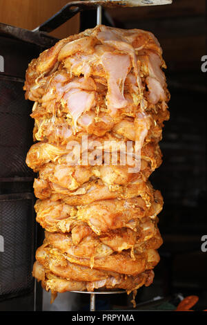 Stücke von rohem Huhn in Gewürzen getränkt und aufgereiht am Spieß für shawarma Stockfoto