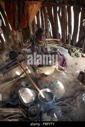 Mumuhuila Stamm Frau kochen in ihrer Hütte, Huila Provinz, Chibia, Angola Stockfoto