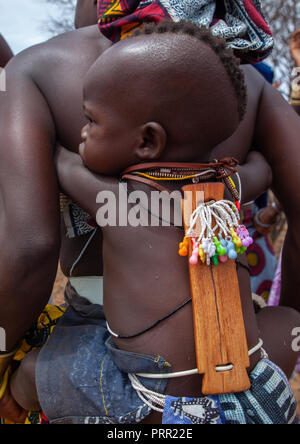 Mucubal Stamm Frau mit ihrem Kind, das Tragen eines ombeleketha Talisman auf der Rückseite, um ihn zu schützen, Provinz Namibe, Virei, Angola Stockfoto