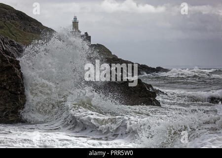 Wellen gegen die Felsen durch Mumbles Leuchtturm in Armband Bay, Swansea, Wales, Großbritannien Stockfoto