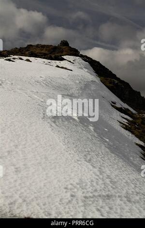 Blick auf die fernen Gipfel des Coniston Old Man. Eis und Schnee bleiben auf der Nordseite. Die englischen Lake District, Cumbria GROSSBRITANNIEN. Stockfoto