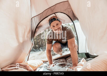 Der bärtige Mann eingabe Zelt übertragen, während sie seine schöne Freundin schlafen Stockfoto