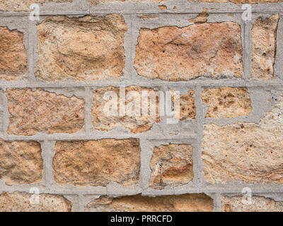 Alte Steinmauer. Alternde Sandsteinwand, die Anzeichen von Zerbröckeln zeigt. Stockfoto