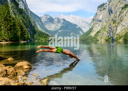 Junger Mann springt in am Obersee, Schwimmen, See, Berg Landschaft, in der Rückseite Watzmann massif, Salet am Königssee Stockfoto