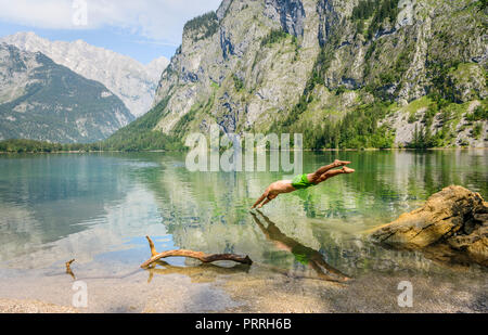 Junger Mann springt in am Obersee, Schwimmen, See, Berg Landschaft, in der Rückseite Watzmann massif, Salet am Königssee Stockfoto