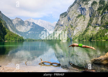 Junger Mann springt in am Obersee, Schwimmen, See, Berg Landschaft, in der Rückseite Watzmann massif, Salet am Königssee Stockfoto